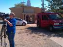 In this 2011 photo, photojournalist Colleen Welcher prepares the camera for the author to go live from a breaking news scene in Wichita Falls, Texas. Notice the van parked on the lawn of a church to keep the mast away from power lines which are just out of frame. [Sierra Harrop, W5DX, photo]  